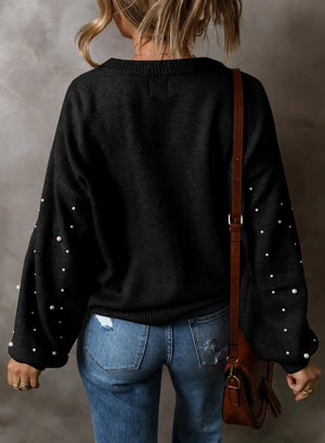 Black long sleeve sweater with pearl embellishments on the sleeves.