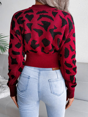 Crimson abstract knit cropped sweater with black pattern, ribbed hem, and crew neck.