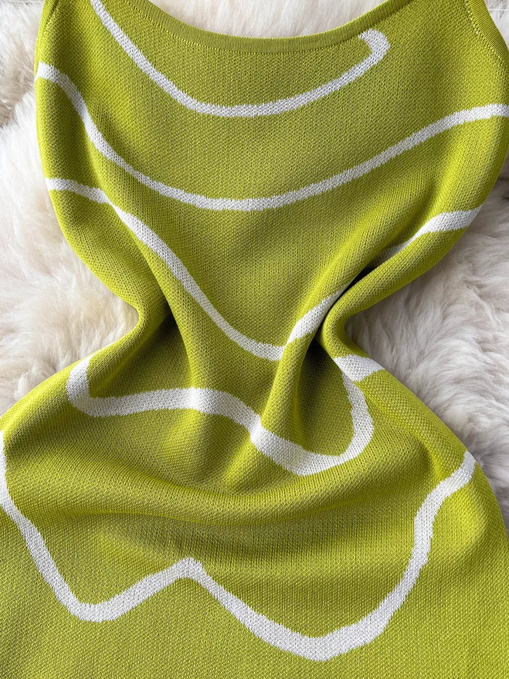 Green wavy knit midi dress with spaghetti straps and white abstract pattern.