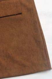 Brown corduroy blazer detail showing a pocket and textured fabric.