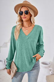 Button-cuff slouch v-neck top in Matcha Green with button detail on sleeves.