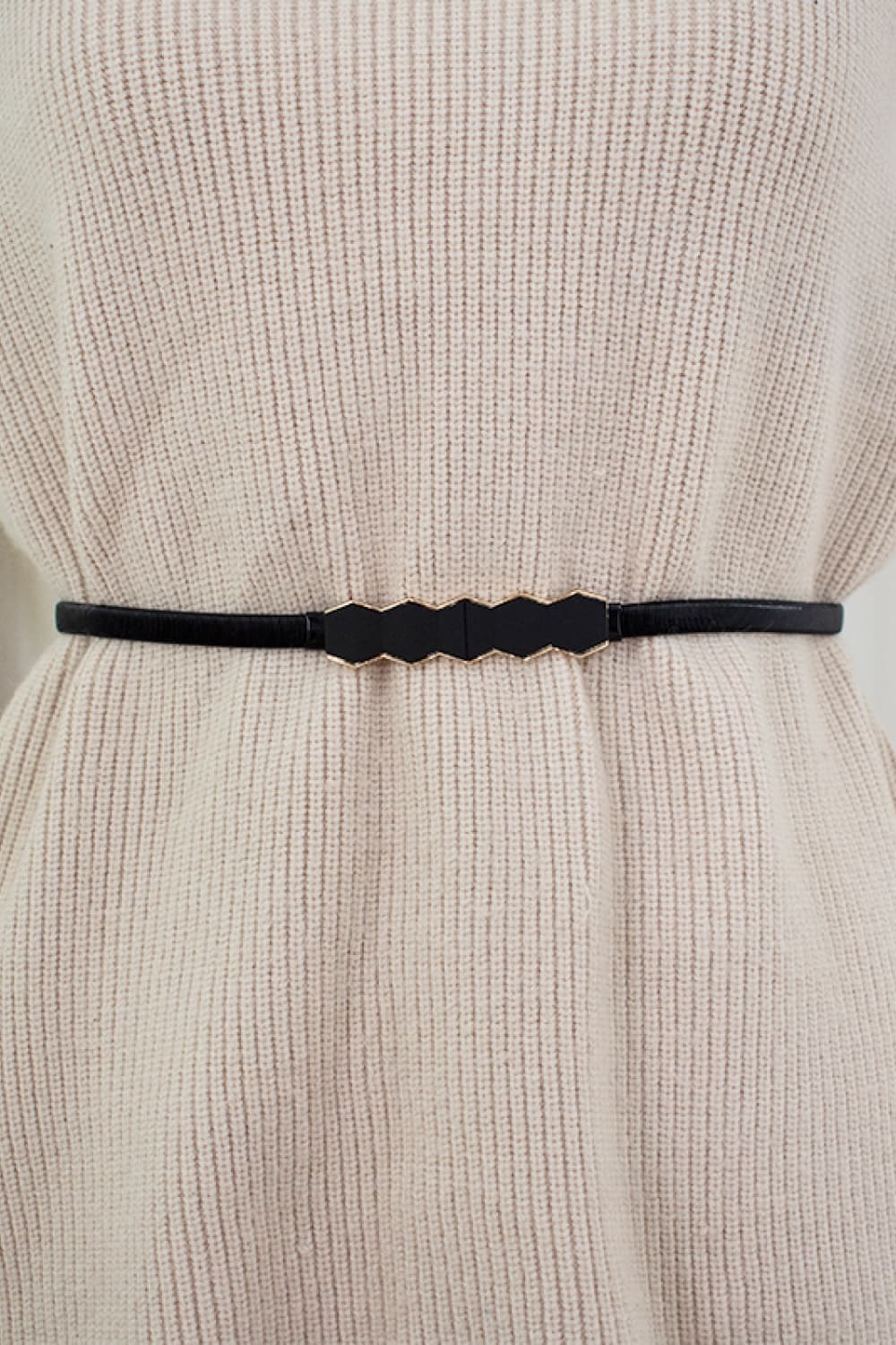 Black geometric buckle waist belt with gold trim, styled on a cream sweater.
