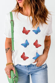 White t-shirt with embroidered red and blue butterfly motifs.