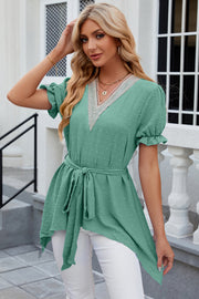 Green dotted swiss blouse with lace trim V-neck, tie waist, and asymmetric hem