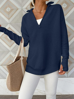 Navy ribbed knit pullover with funnel neck and quarter zip, long sleeves with thumbholes.