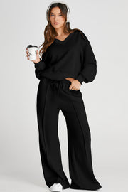 Black V-neck lounge set with seam detail pants and drawstring waist.
