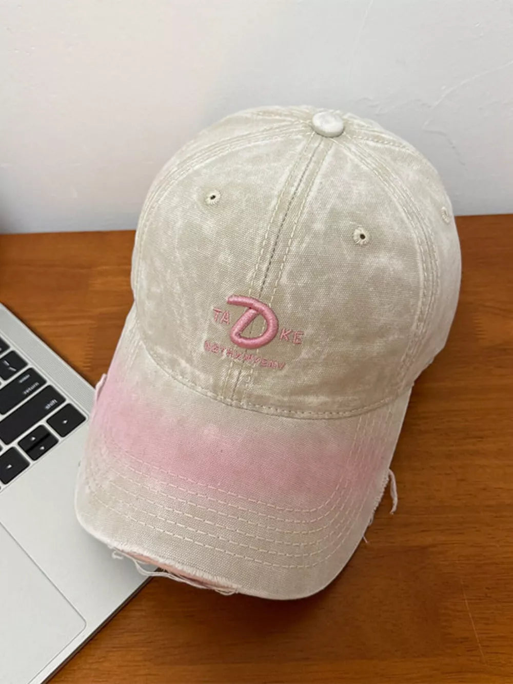 Embroidered vintage denim baseball cap in khaki with pink ombre brim and distressed details.