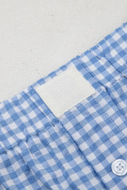 Light blue gingham boxer shorts with a white woven label and button detail.