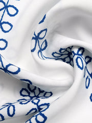 Bohemian maxi skirt with blue floral embroidery on white fabric.