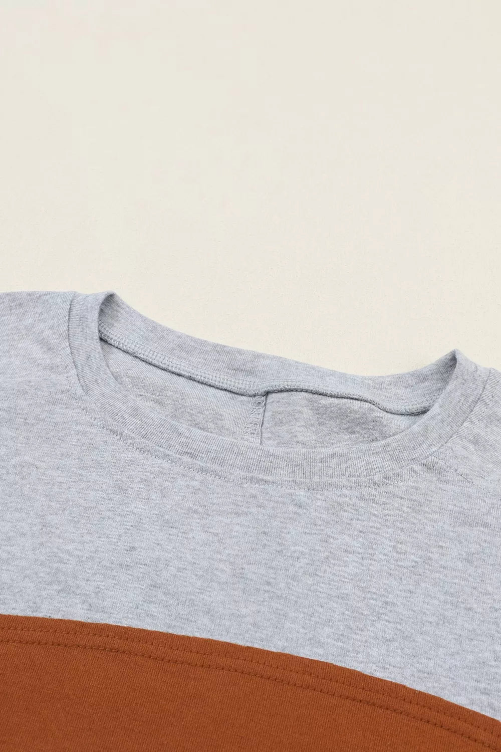 Maternity shirt in gray and mustard colorblock with crew neck and bishop sleeves.