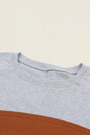 Maternity shirt in gray and mustard colorblock with crew neck and bishop sleeves.