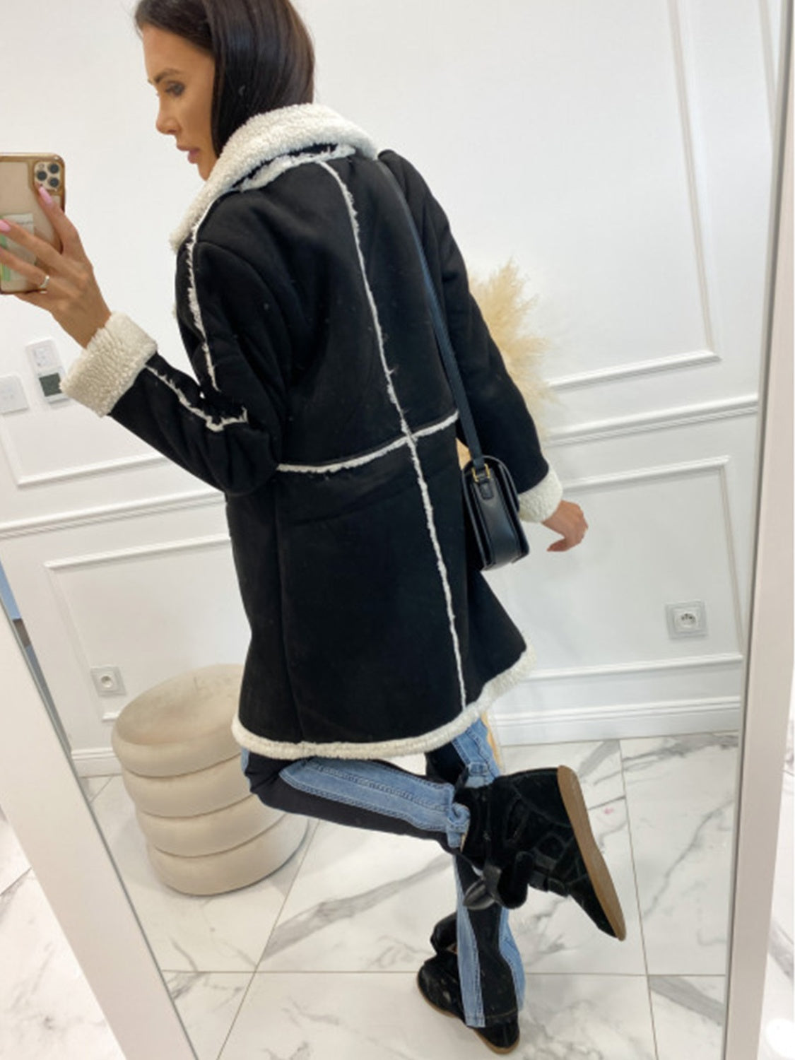 Black suede effect overcoat with white shearling trim and collar, long sleeves.