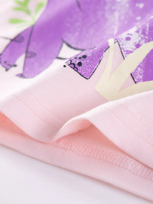 Toddler t-shirt in blush pink with a playful purple dinosaur graphic and green leaves.