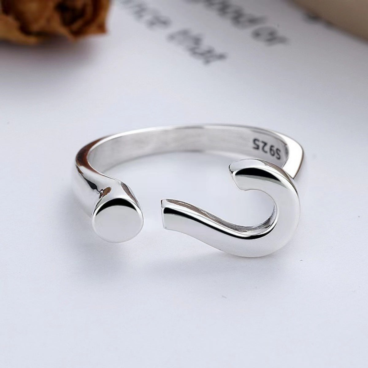 Sterling silver open ring with a question mark design and adjustable fit.