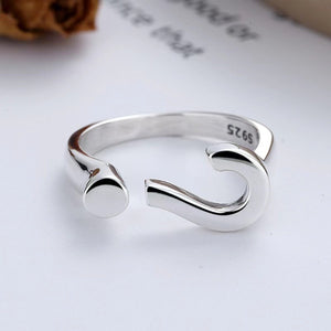 Sterling silver open ring with a question mark design and adjustable fit.