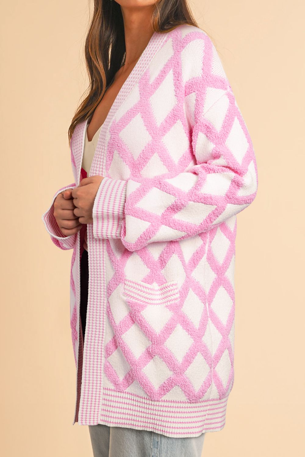 Diamond jacquard knit open cardigan in blush pink with textured diamonds and contrast trim.