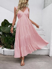 Blush pink tiered maxi dress with flutter sleeves and V-neck, flowing skirt.