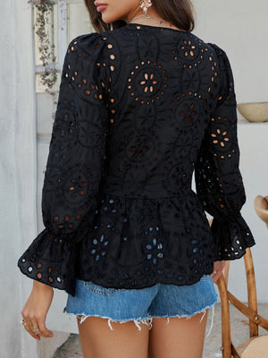 Black eyelet embroidered peplum blouse with puff sleeves and ruffled cuffs.
