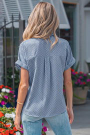 Blue polka dot short sleeve polyester shirt with cuffed sleeves and back pleats.