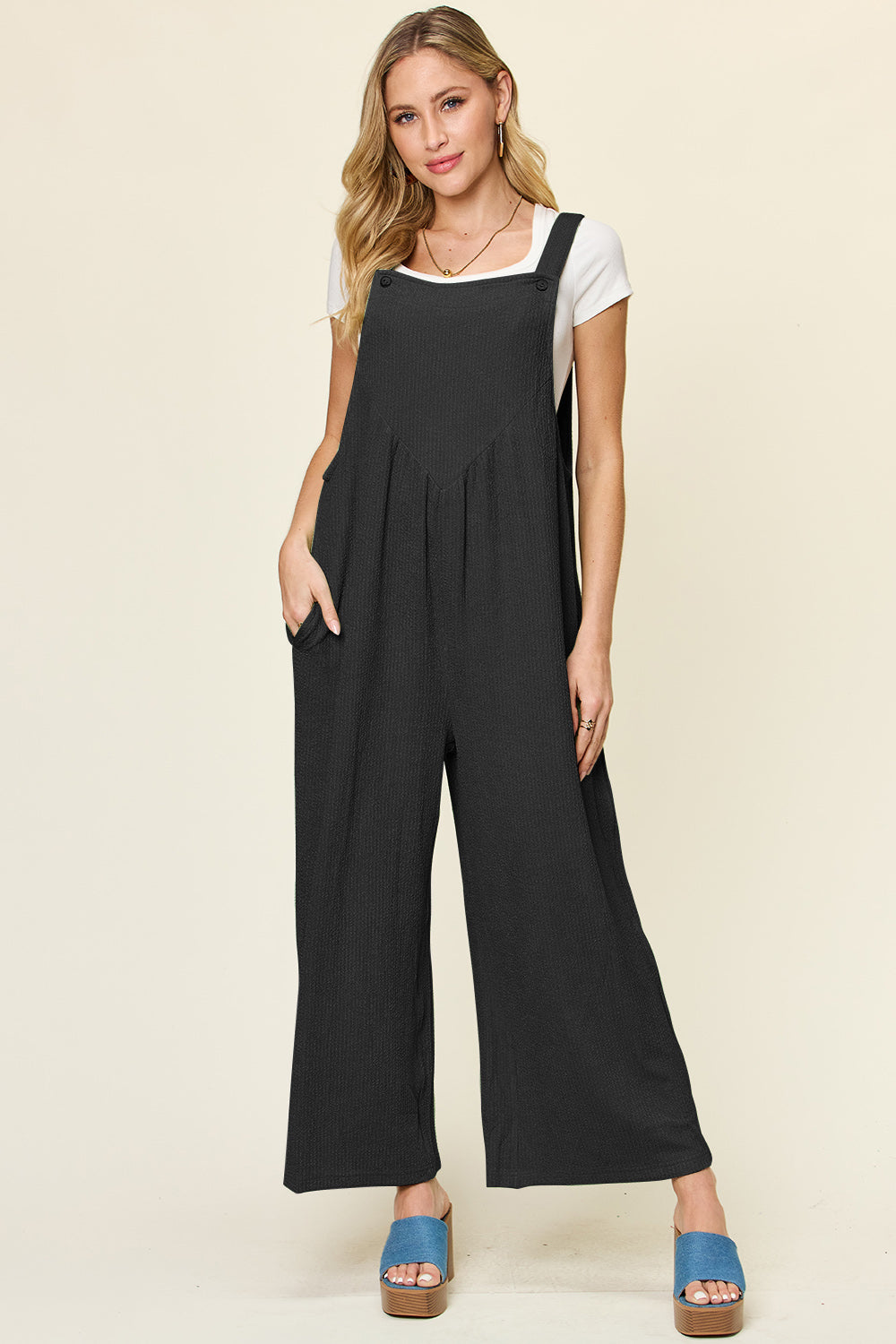 Ribbed black wide-leg pinafore jumpsuit with square neckline and pockets