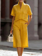 Yellow two-piece set with pocketed top and wide-leg pants, styled with a white handbag.