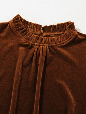 Brown velvet mock neck blouse with ruffled neckline and gathered detail.