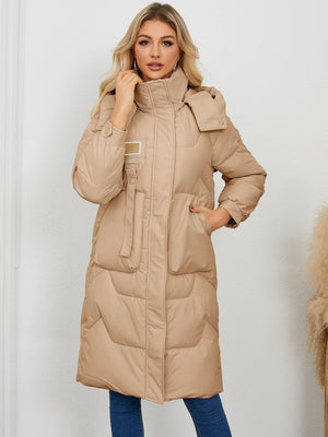 Camel quilted puffer parka with buckle detail and hood.