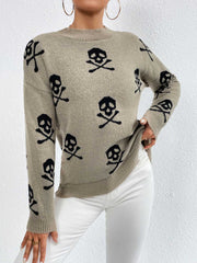 Khaki knit sweater with allover black skull and crossbones motif, drop shoulder, and crew neck.