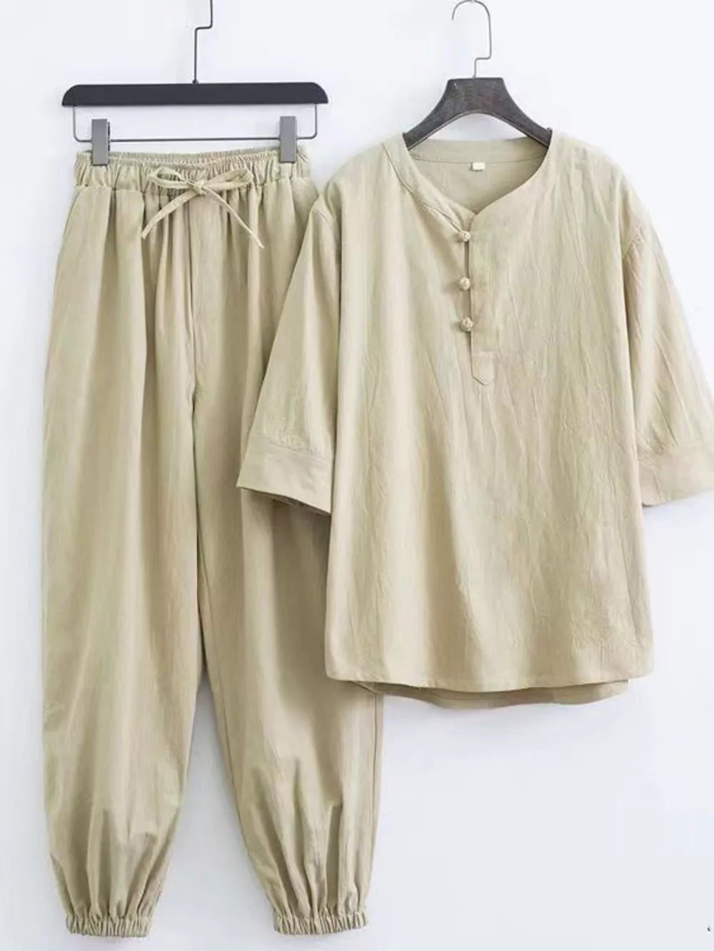 Relaxed fit beige Chinese-inspired men's pants set with drawstring waist and button-up tunic.