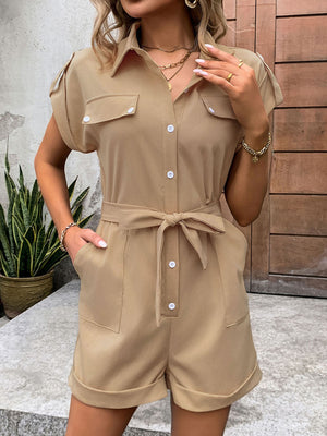 Camel utility romper with tie-waist detail, collared, short sleeves, button-down front, and cuffed shorts.