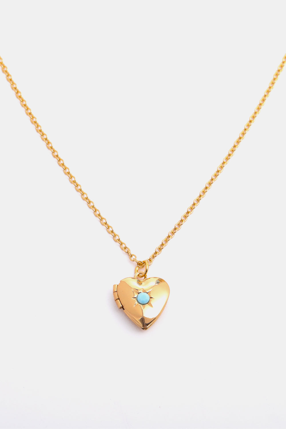 Gold heart locket necklace with turquoise gemstone detail on a delicate chain.