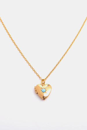 Gold heart locket necklace with turquoise gemstone detail on a delicate chain.