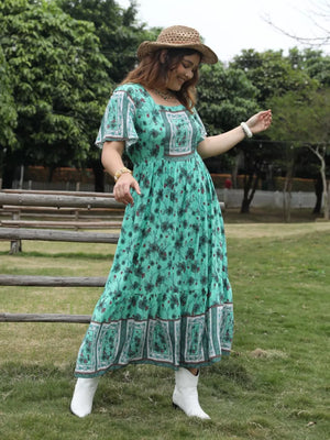 Green floral maxi dress with square neck, short sleeves, and tiered skirt.