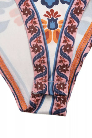 Bodysuit with vibrant floral print, pink trim, and snap closure detail.