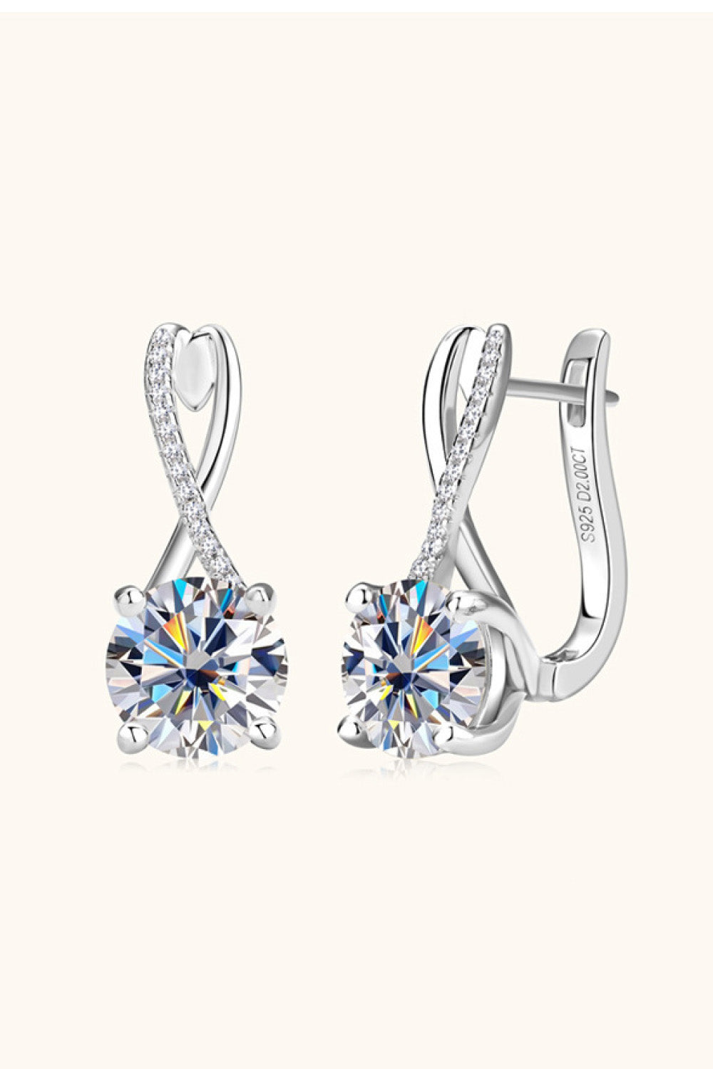 Silver crossover moissanite huggie earrings with diamond accents.