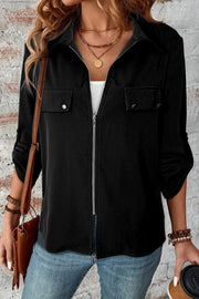 Black zip-front blouse with chest pockets and rolled sleeves.