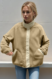 Tan fleece bomber jacket with contrast trim and snap front closure.