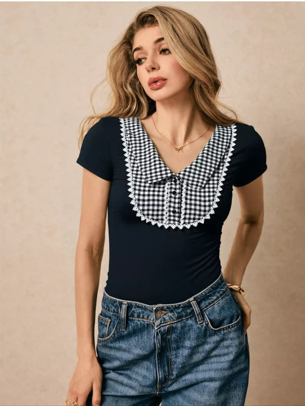 Black maternity shirt with gingham collar and lace trim, short sleeves, decorative buttons.