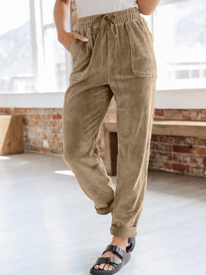 Corduroy drawstring tapered trousers in camel with pockets.