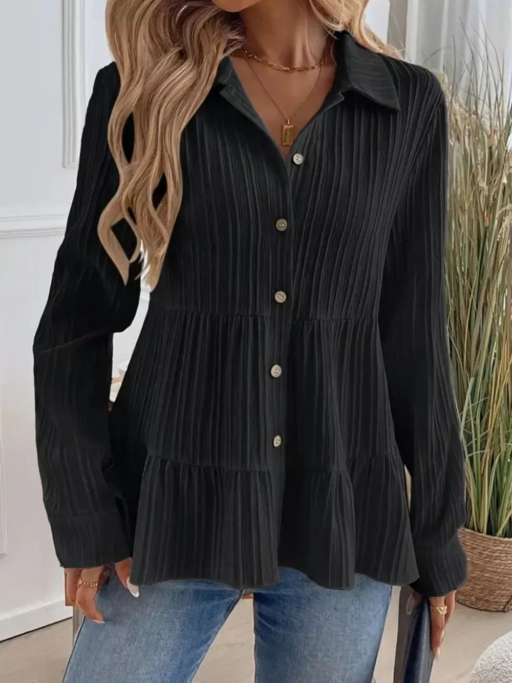 Black textured tiered button-down shirt with crinkled fabric and button details.