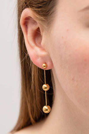 Gold triple orb drop earrings with delicate chains.