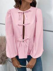 Blush pink peplum blouse with keyhole neckline and bow details, long puffed sleeves.
