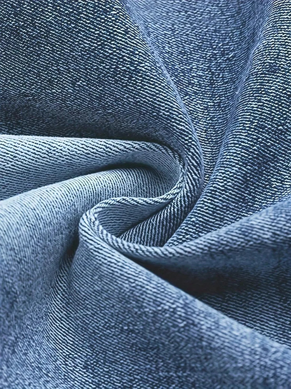 Blue cotton denim fabric detail, showing texture and weave.