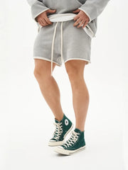 Gray fleece lounge shorts with raw edge hem and drawstring waist.