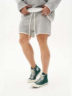 Gray fleece lounge shorts with raw edge hem and drawstring waist.