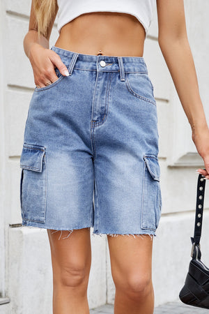 Medium wash denim bermuda shorts with raw hemline and cargo pockets.