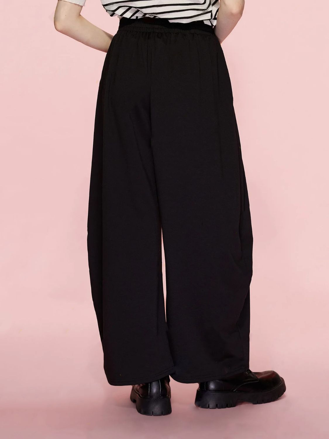 Black pleated drape palazzo trousers with wide legs and an elastic waistband.