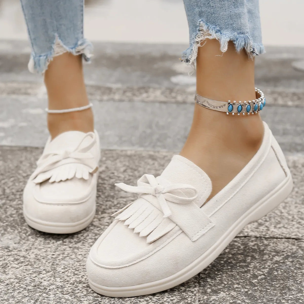 Ivory fringe bow loafer flats with a bow detail and fringe accent.
