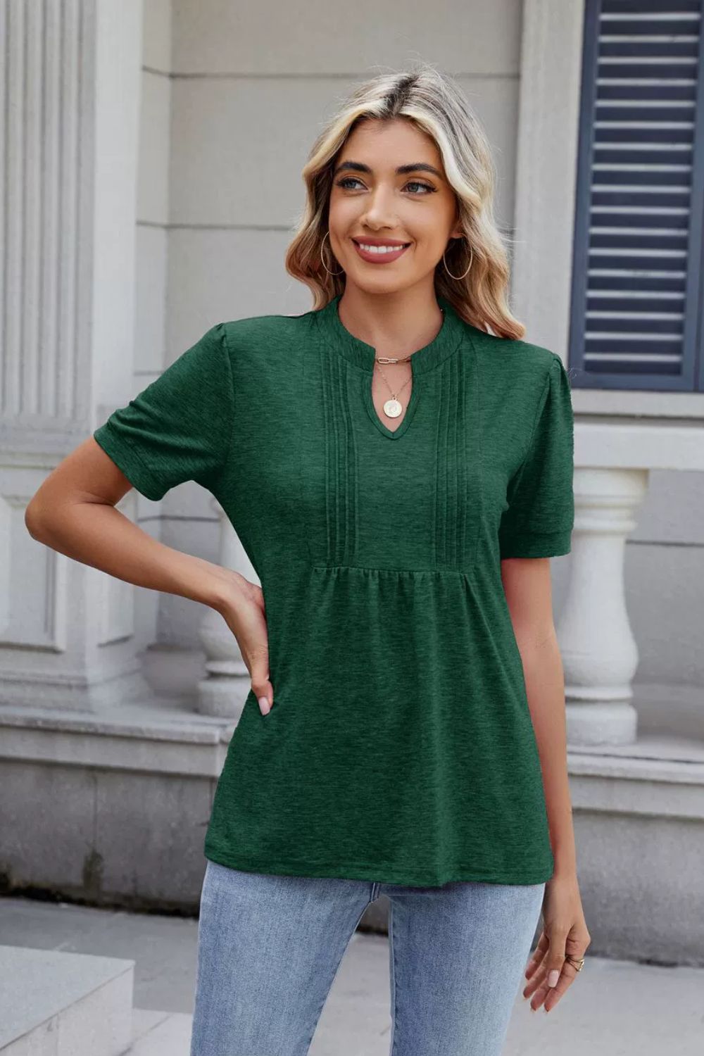 Dark green pleated yoke henley tee with keyhole neckline and short sleeves.