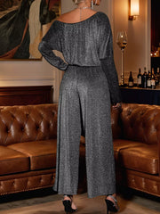 Gray glitter one-shoulder jumpsuit with wide-leg pants and long sleeves.